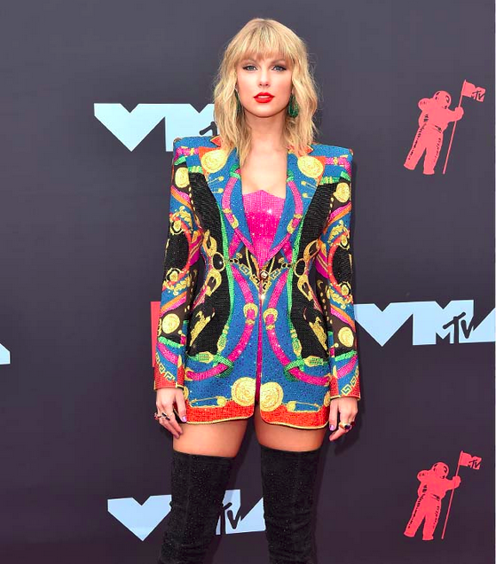 Taylor Swift in a psychedelic jacket. And extremely long black boots.